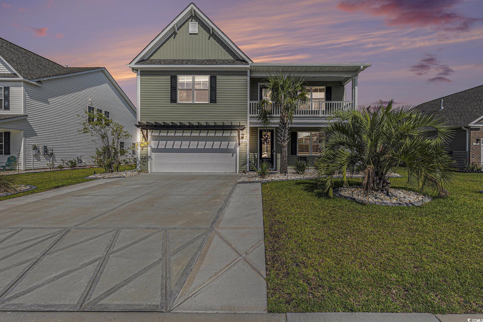 312 Cattle Drive Circle Myrtle Beach, SC 29588 - Photo 33 of 34 View of front of house featuring a balcony, concrete driveway, a garage, and a front yard