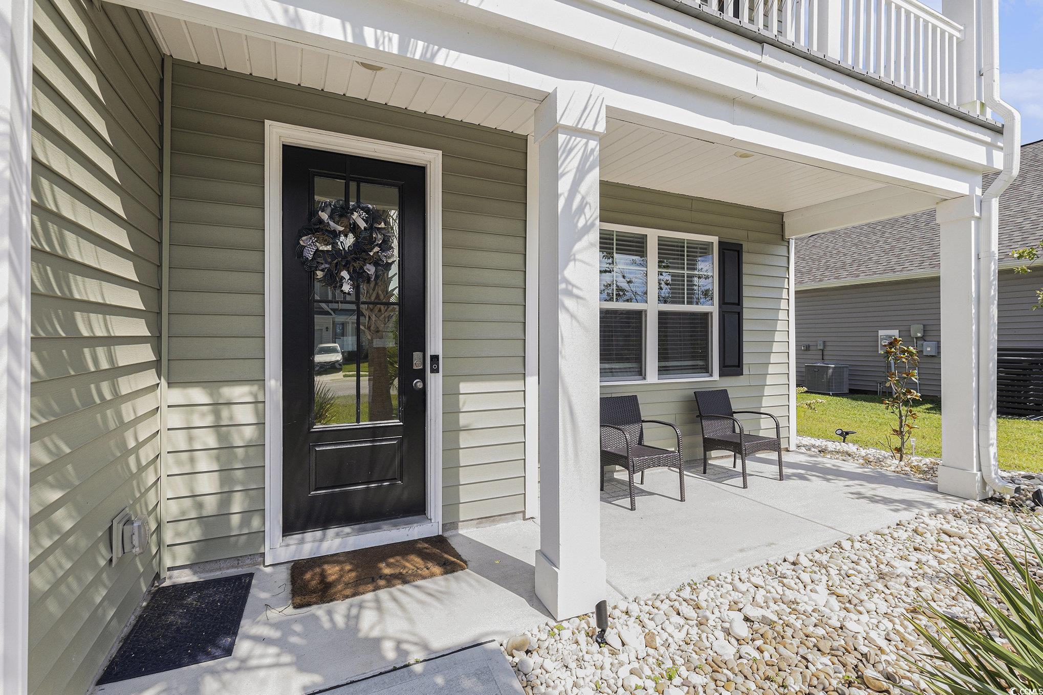 312 Cattle Drive Circle Myrtle Beach, SC 29588 - Photo 4 of 34 View of front facade featuring a balcony, concrete driveway, an attached garage, and a front yard