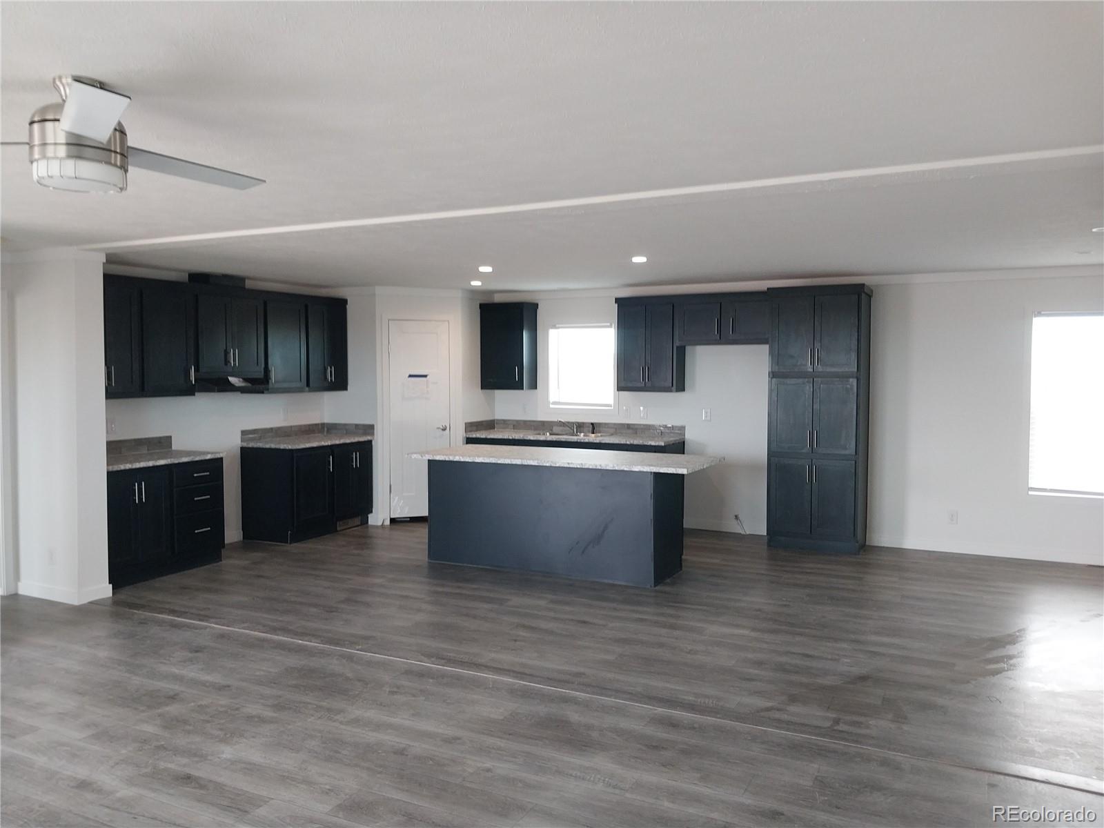 776 North Ramah Highway Yoder, CO 80864 - Photo 12 of 18 a large kitchen with stainless steel appliances granite countertop a stove a sink dishwasher a refrigerator and a oven with wooden floor