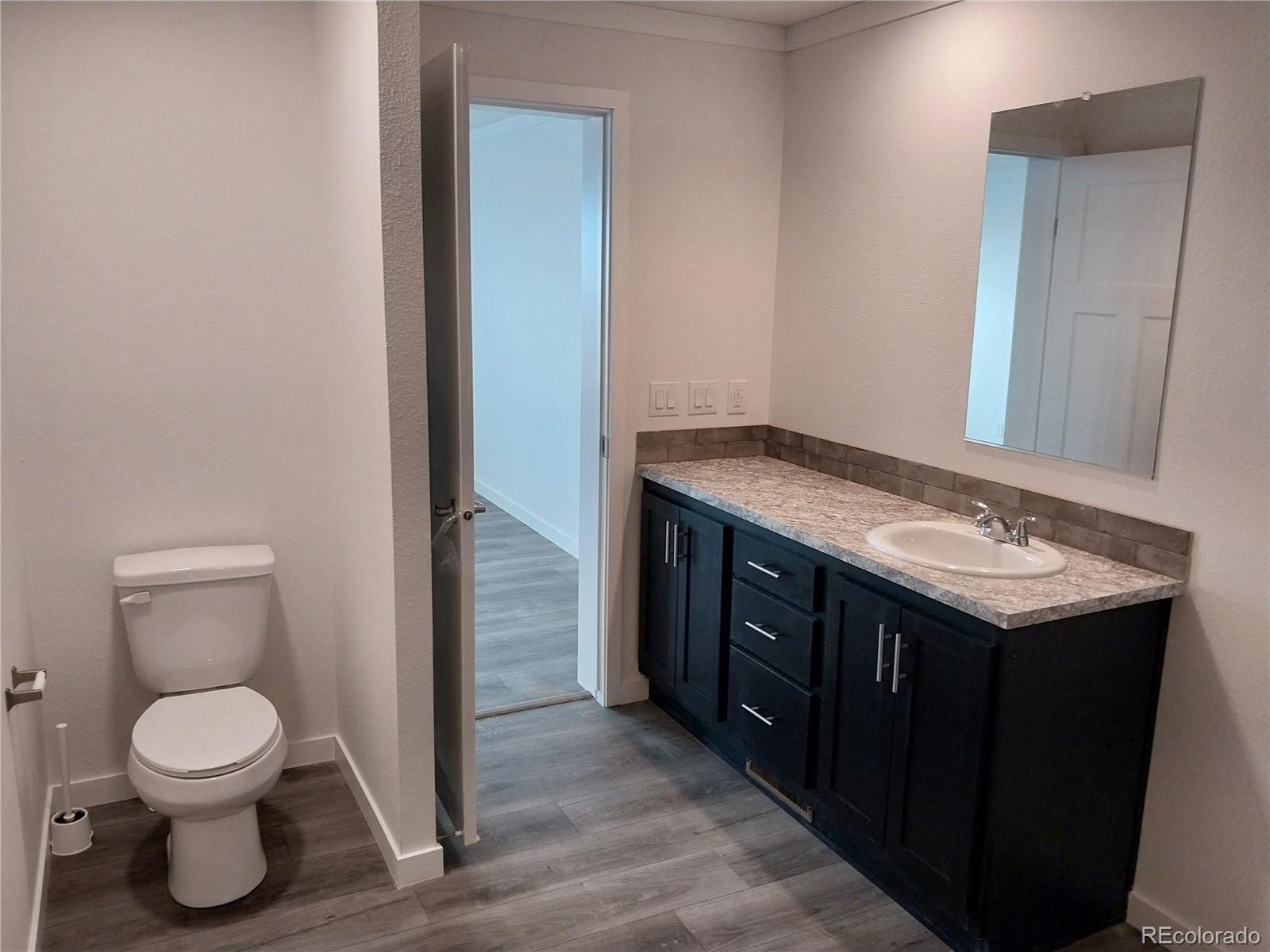 776 North Ramah Highway Yoder, CO 80864 - Photo 15 of 18 a bathroom with a granite countertop toilet and a sink