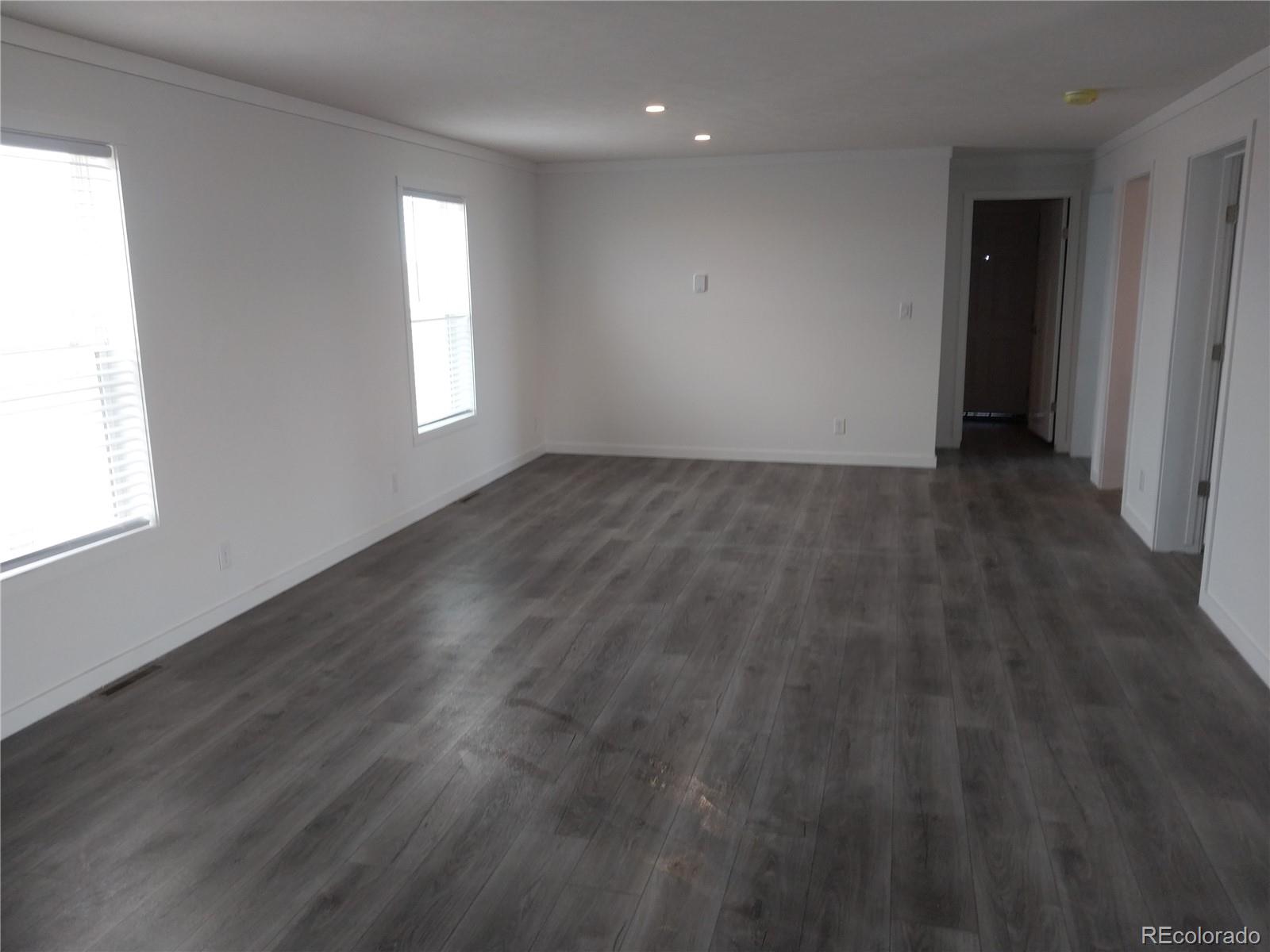 776 North Ramah Highway Yoder, CO 80864 - Photo 7 of 18 an empty room with wooden floor and windows