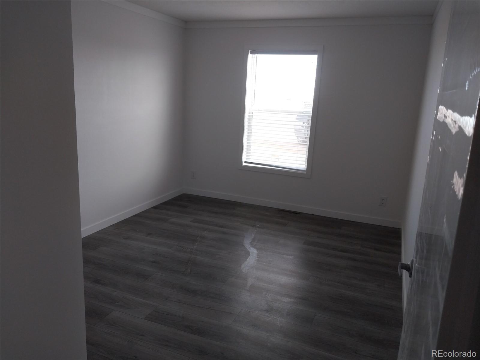776 North Ramah Highway Yoder, CO 80864 - Photo 8 of 18 an empty room with wooden floor and windows