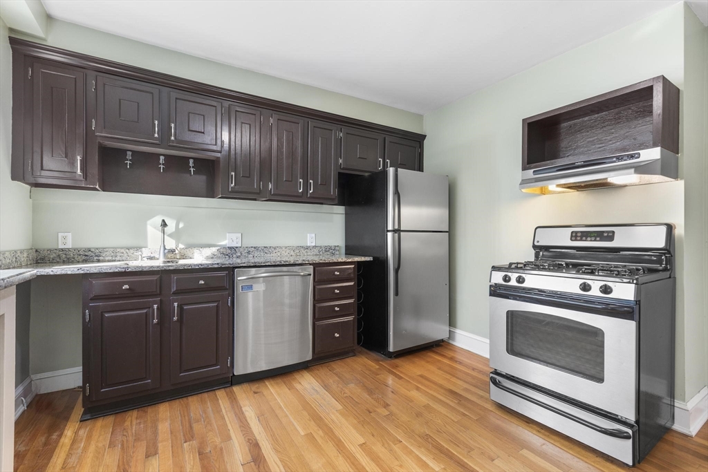 a kitchen with granite countertop wooden cabinets stainless steel appliances and a counter space