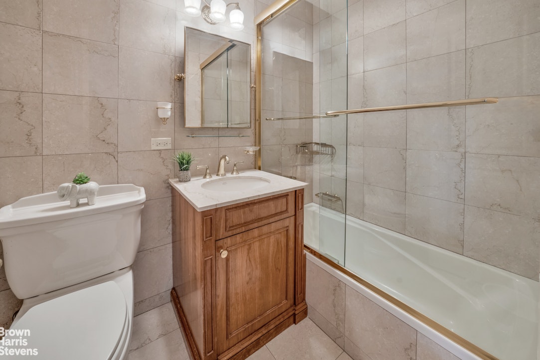 10 West 66th Street, Unit 23G Manhattan, NY 10023 - Photo 10 of 19 a bathroom with a sink a toilet and shower