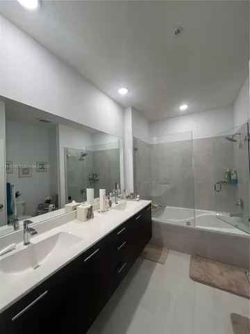 a bathroom with a double vanity sink mirror double and bathtub