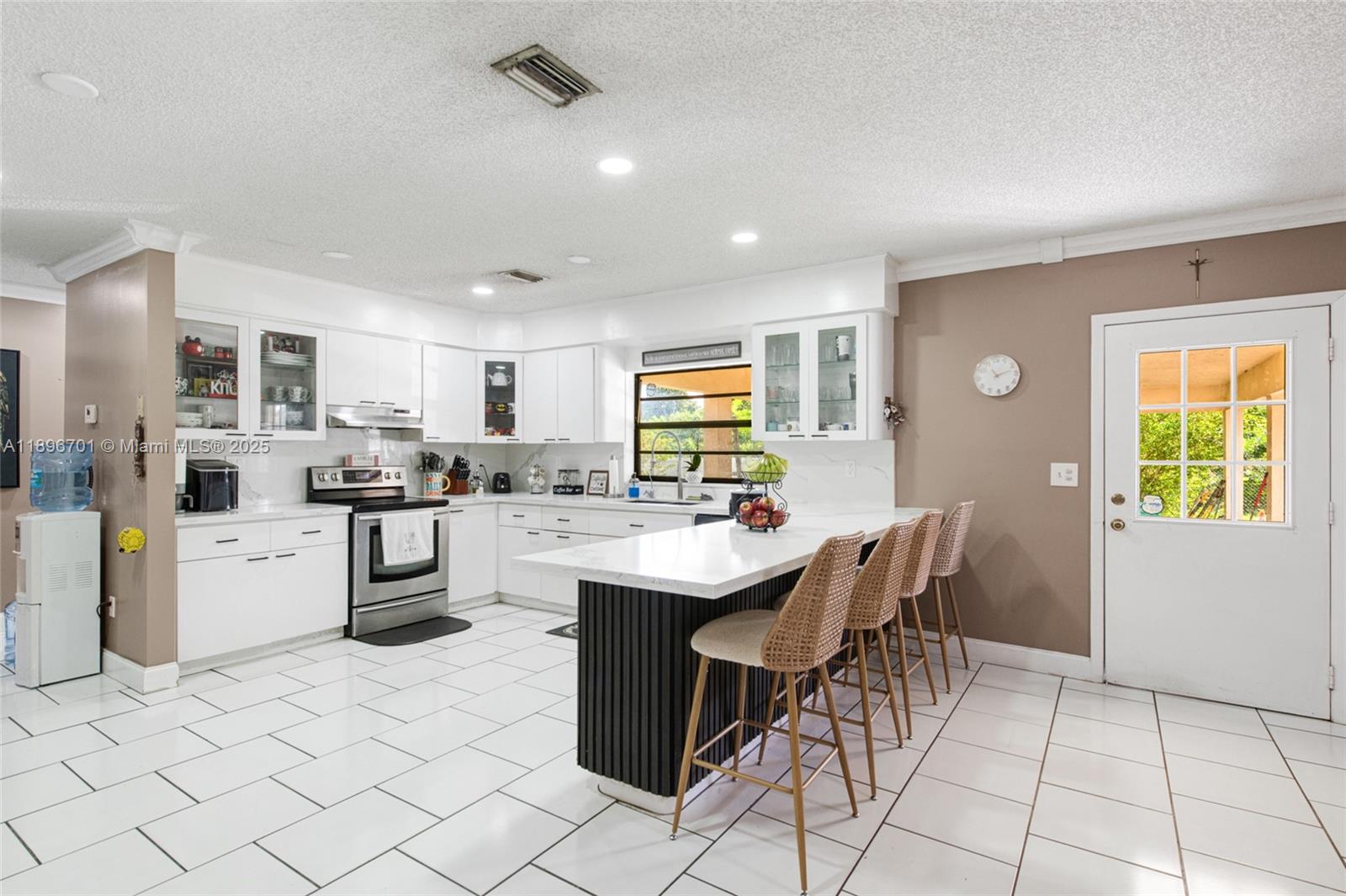 19491 Southwest 216th Street Miami, FL 33187 - Photo 12 of 37 a kitchen with cabinets and chairs