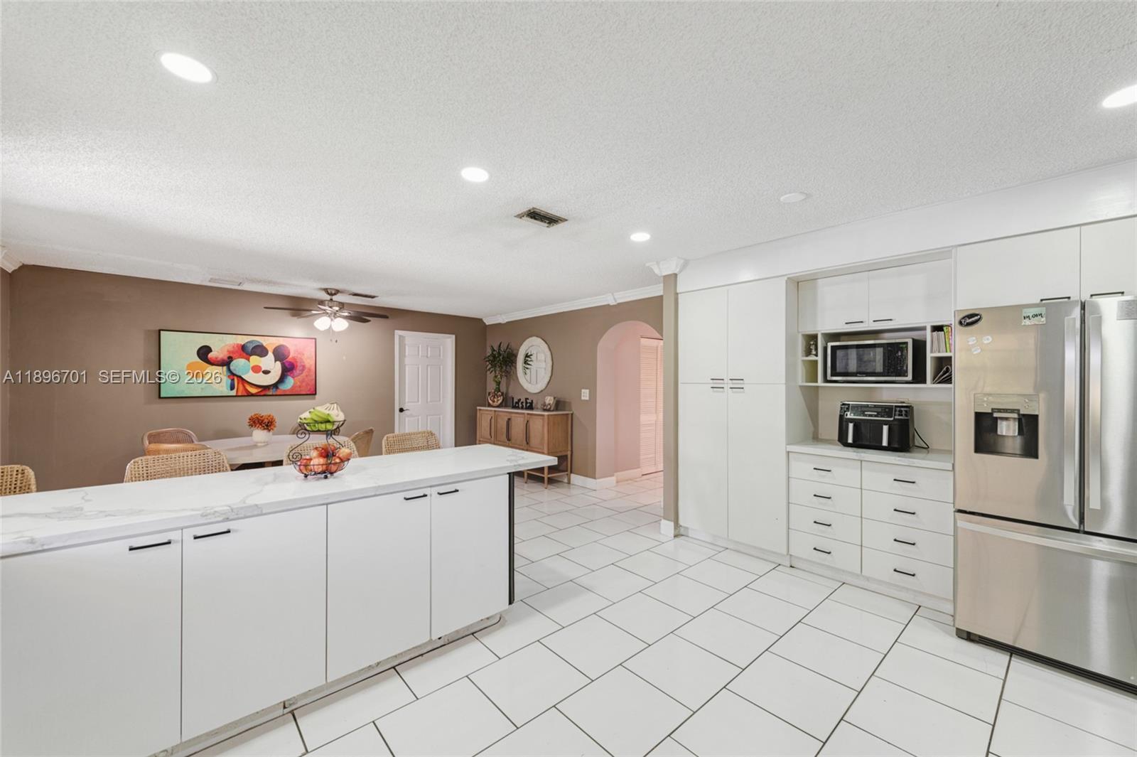 19491 Southwest 216th Street Miami, FL 33187 - Photo 17 of 32 a kitchen that has a lot of cabinets and refrigerator