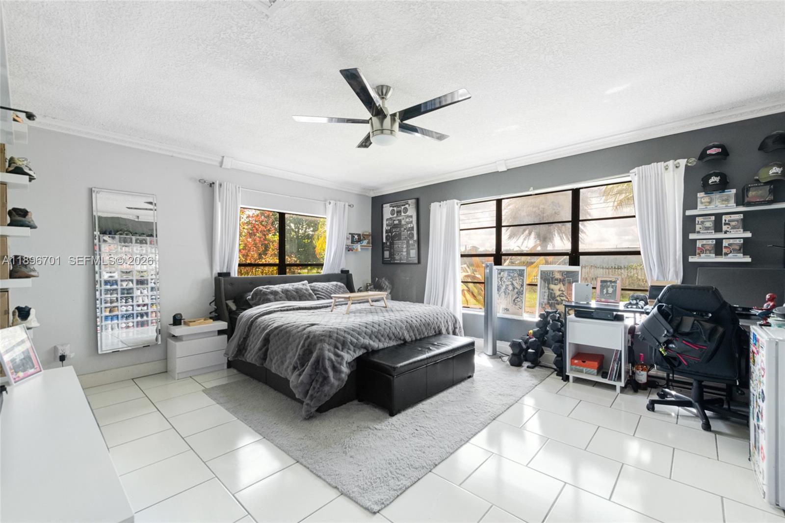 19491 Southwest 216th Street Miami, FL 33187 - Photo 22 of 32 a spacious bedroom with a bed and large windows