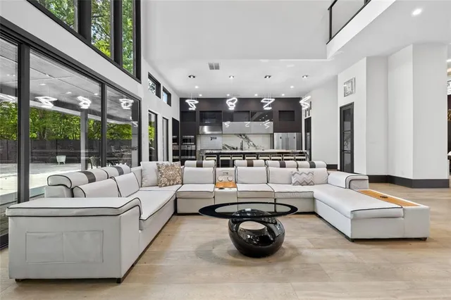 a large kitchen with stainless steel appliances a large counter top a stove and a refrigerator with wooden floor