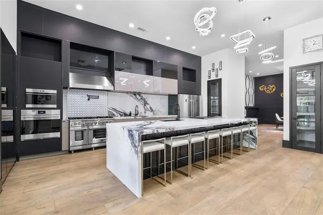 a kitchen with a sink a stove and chairs