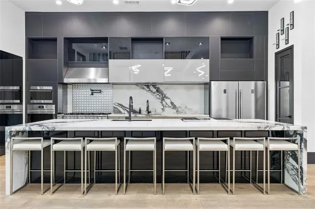 a large kitchen with kitchen island granite countertop a large counter top stainless steel appliances and cabinets