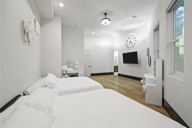 a spacious bedroom with a bed and a large window