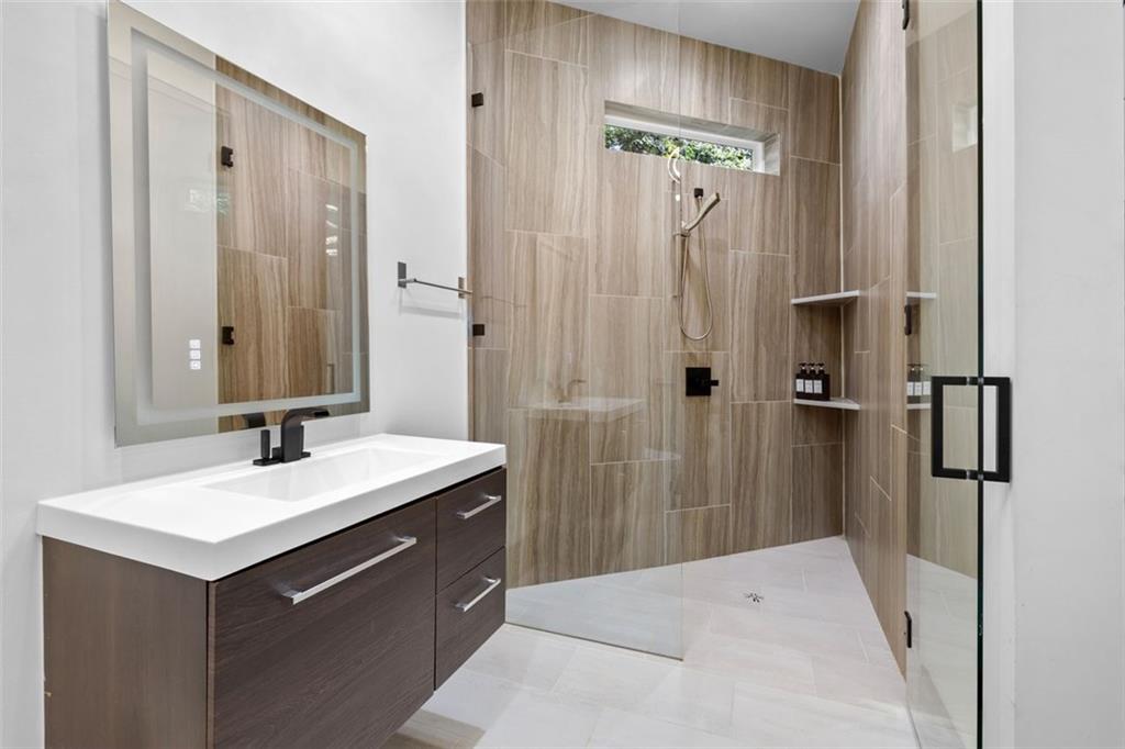 2401 Greenglade Road Northeast Atlanta, GA 30345 - Photo 48 of 64 a bathroom with a sink a mirror a vanity and a shower