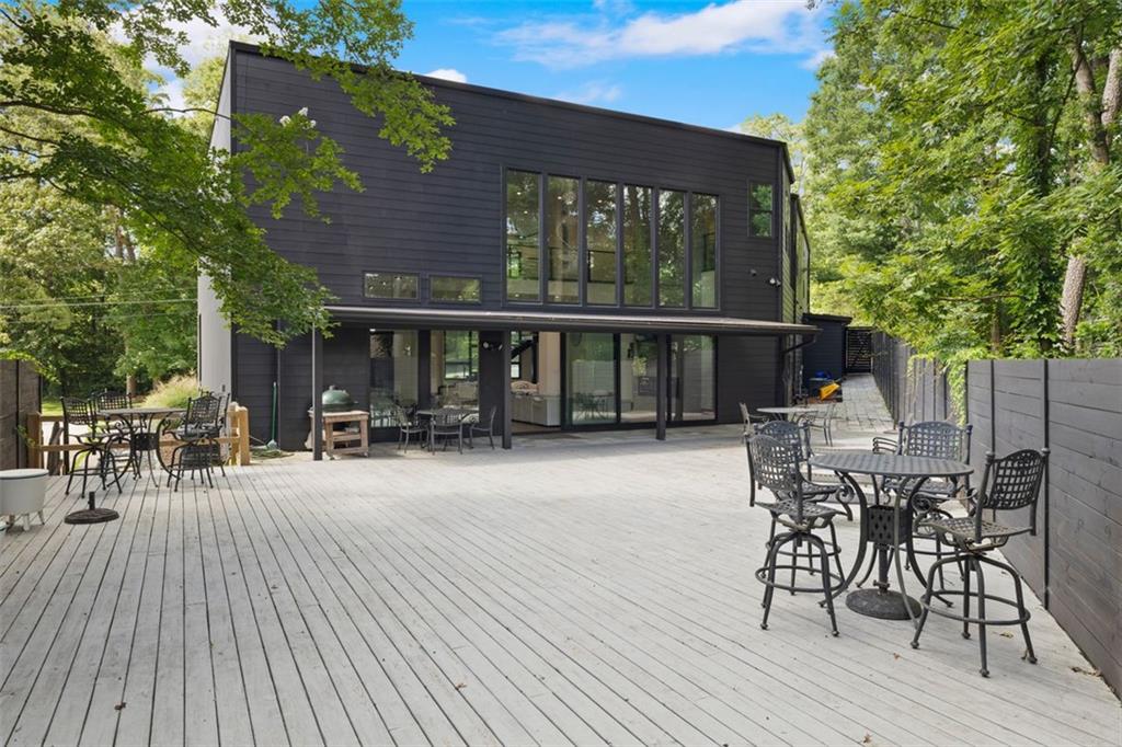 2401 Greenglade Road Northeast Atlanta, GA 30345 - Photo 53 of 64 a patio with table and chairs and potted plants with wooden floor and fence