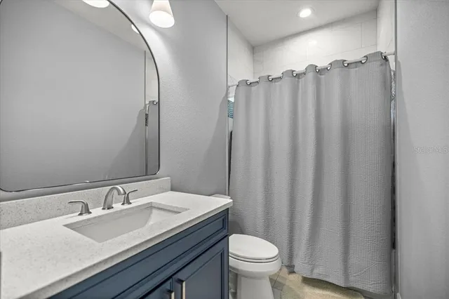 a bathroom with a sink a toilet and shower curtain