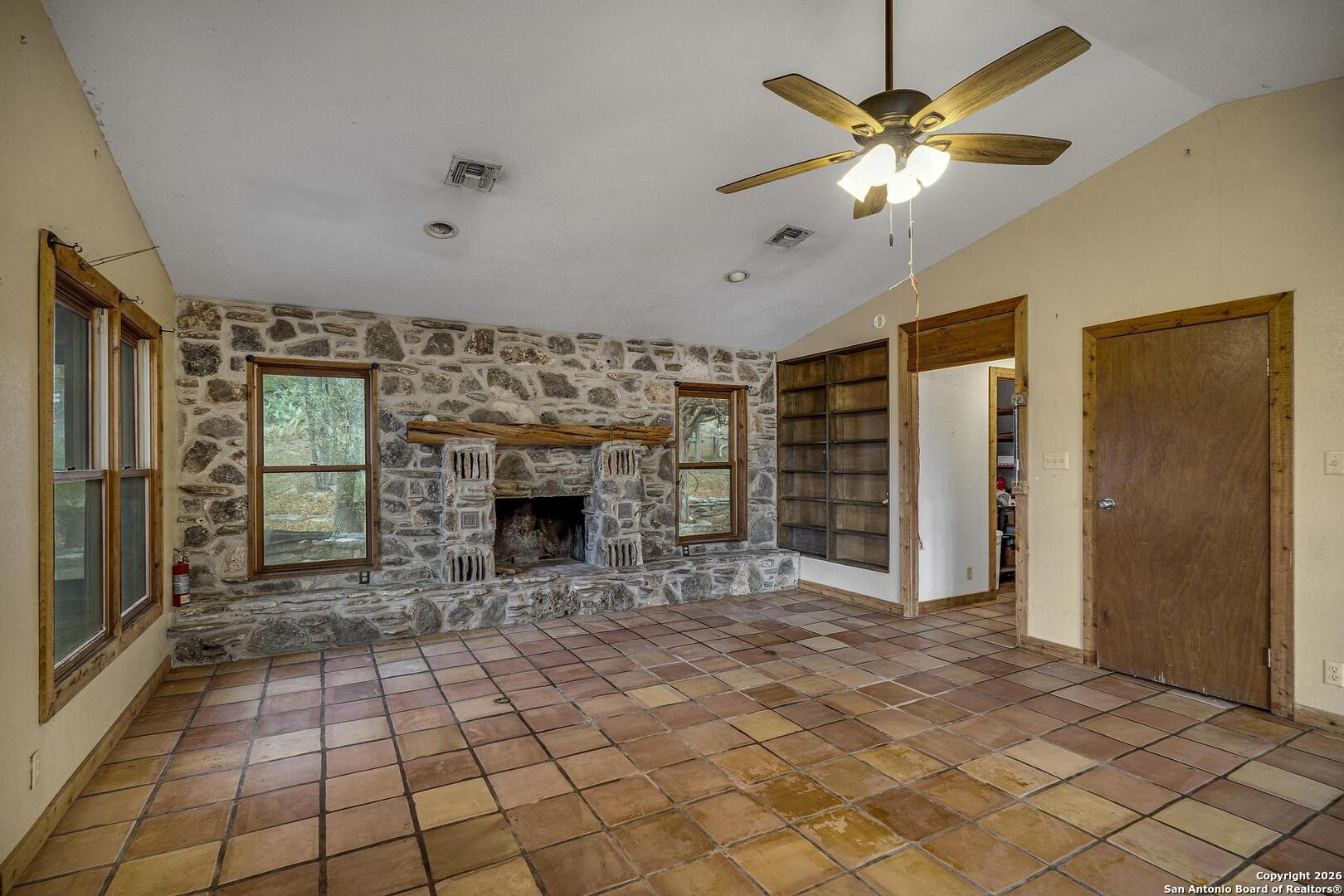 360 Kirk Lane Bulverde, TX 78163 - Photo 7 of 50 a view of a livingroom with a fireplace a chandelier fan and windows