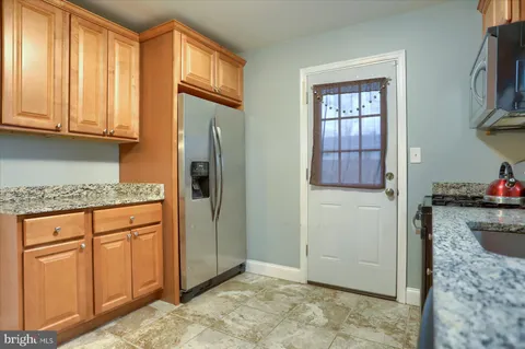 a kitchen with stainless steel appliances granite countertop a refrigerator and cabinets