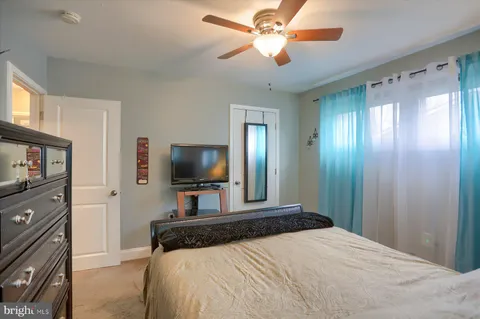 a bedroom with a bed and a flat tv screen on wall