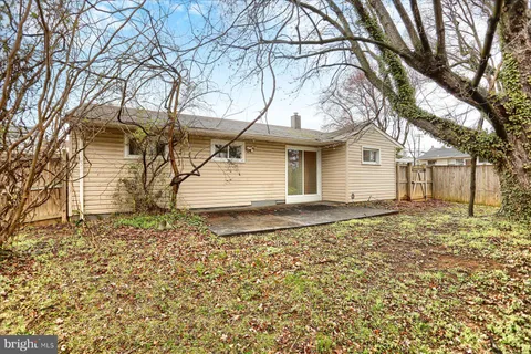 a backyard of a house with large trees and barbeque oven