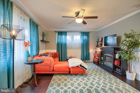 a living room with furniture a flat screen tv and a lamp