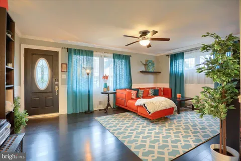 a bedroom with wooden floor and a chandelier