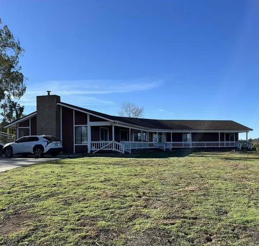 a view of a house with yard and sitting area
