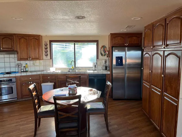 a kitchen with kitchen island granite countertop wooden floors and stainless steel appliances