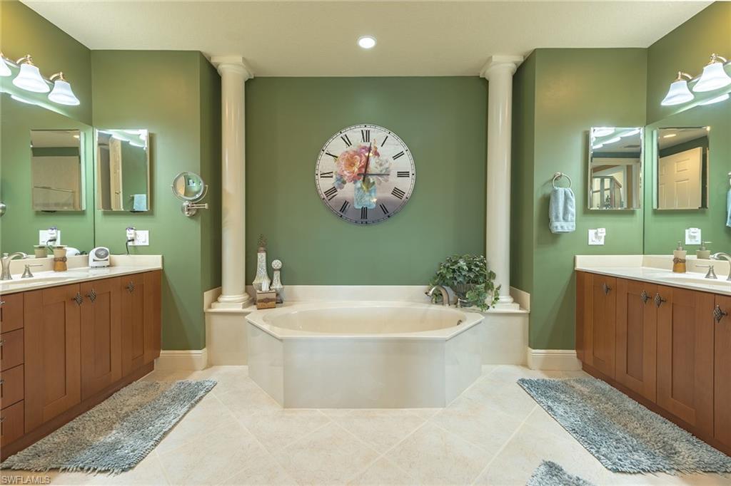9233 Museo Circle, Unit 103 Naples, FL 34114 - Photo 12 of 49 a spacious bathroom with a bathtub sink and mirror