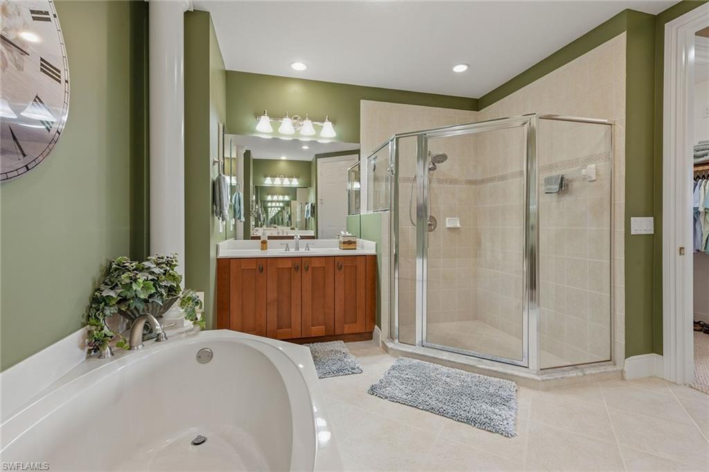 9233 Museo Circle, Unit 103 Naples, FL 34114 - Photo 13 of 49 a bathroom with a tub sink and mirror