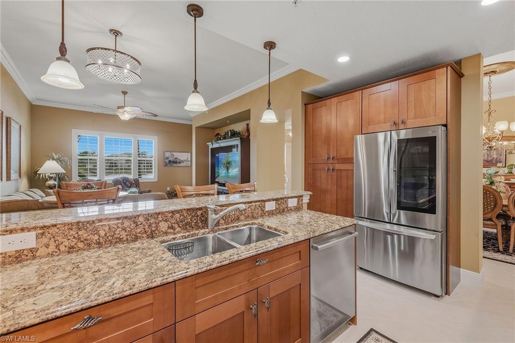 9233 Museo Circle, Unit 103 Naples, FL 34114 - Photo 2 of 49 a kitchen with granite countertop a sink and refrigerator