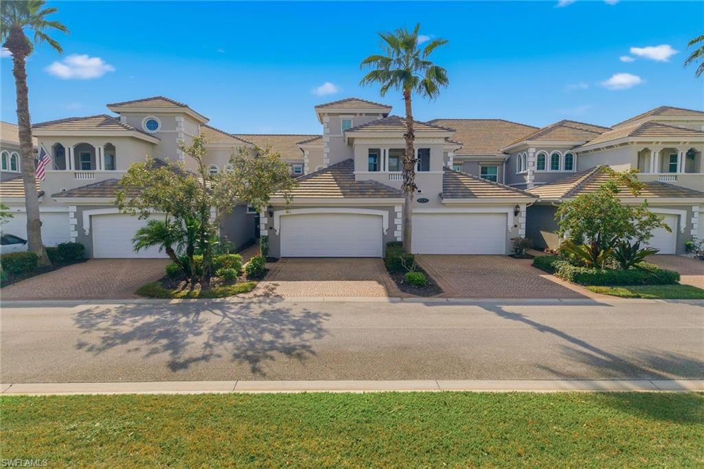 9233 Museo Circle, Unit 103 Naples, FL 34114 - Photo 26 of 49 a front view of a house with a yard and garage