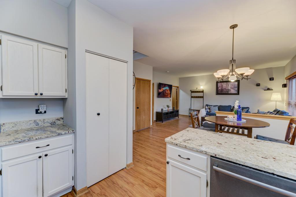 460 Springwood Lane Bolingbrook, IL 60440 - Photo 13 of 35 a open kitchen with granite countertop a sink dishwasher and white cabinets with wooden floor