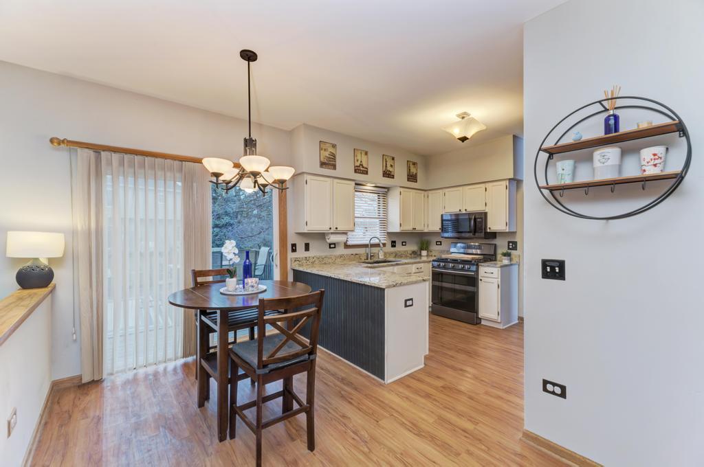 460 Springwood Lane Bolingbrook, IL 60440 - Photo 14 of 35 a kitchen with a table chairs and a wooden floor
