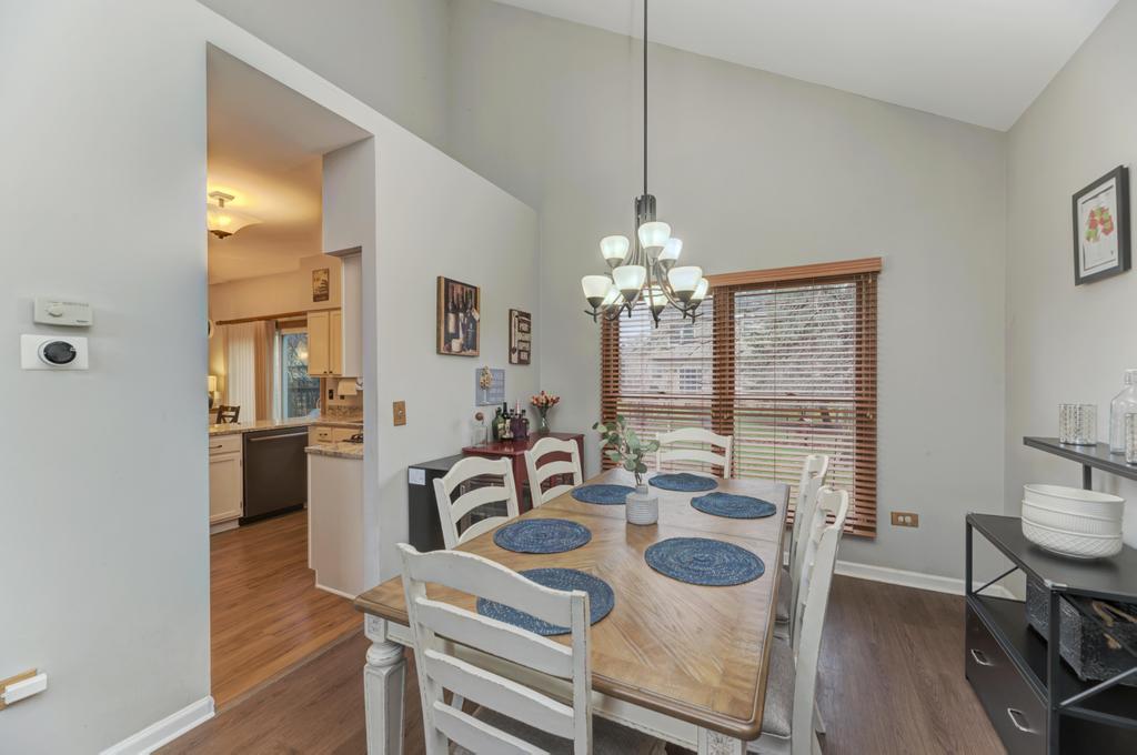 460 Springwood Lane Bolingbrook, IL 60440 - Photo 8 of 35 a view of a dining room with furniture a chandelier and wooden floor