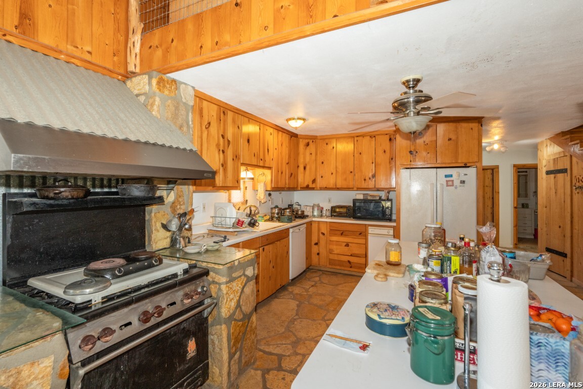 3655 North Seco Creek Road Medina, TX 78055 - Photo 26 of 45 a kitchen with a stove a sink and a refrigerator