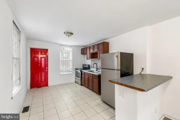a kitchen with a refrigerator and a stove top oven