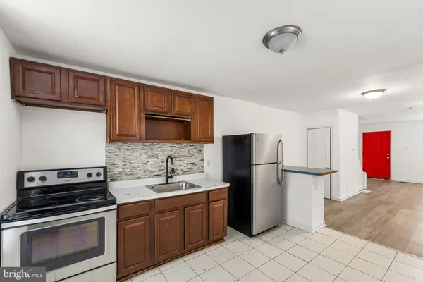 a kitchen with stainless steel appliances granite countertop a refrigerator stove and sink