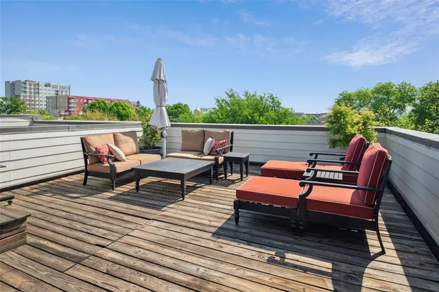 a roof deck with outdoor seating and city view