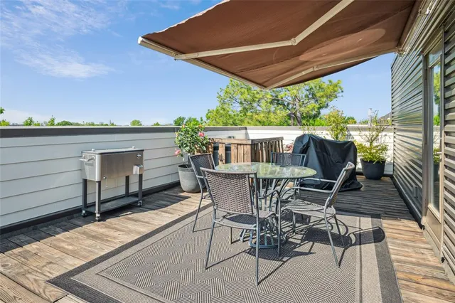 a view of a patio with table and chairs with wooden floor and fence