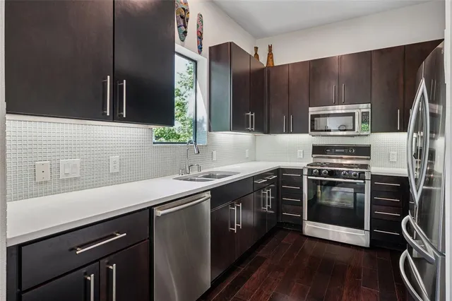 a kitchen with a sink appliances and cabinets