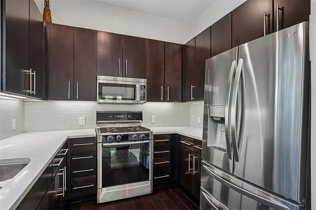 a kitchen with wooden cabinets and stainless steel appliances