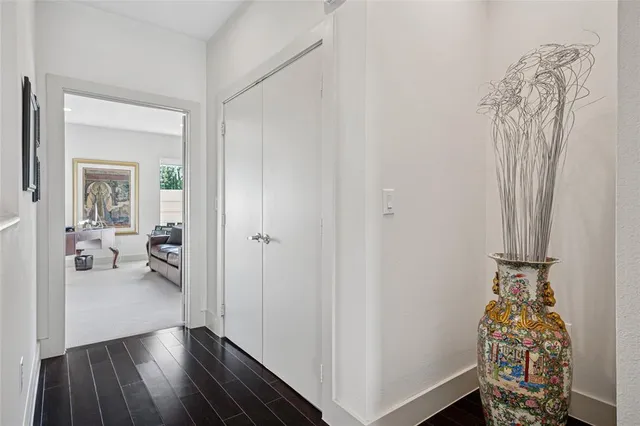 a view of a hallway with wooden floor and a livingroom with furniture