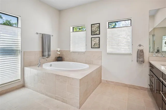 a en suite bathroom with a tub sink and mirror