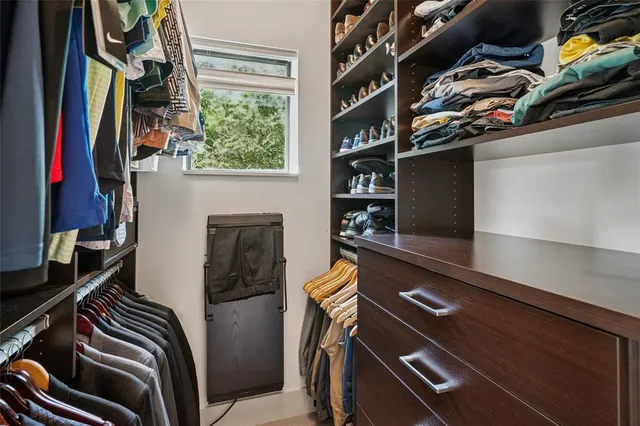 a view of walk in closet with clothes and shoes