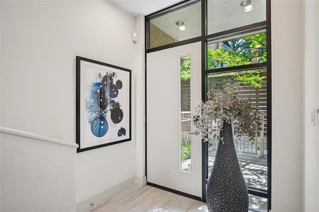 a view of a hallway with wooden floor and a potted plant
