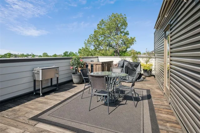 a view of a patio with table and chairs with wooden floor and fence