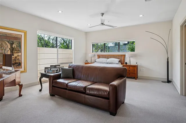 a bedroom with furniture and large windows