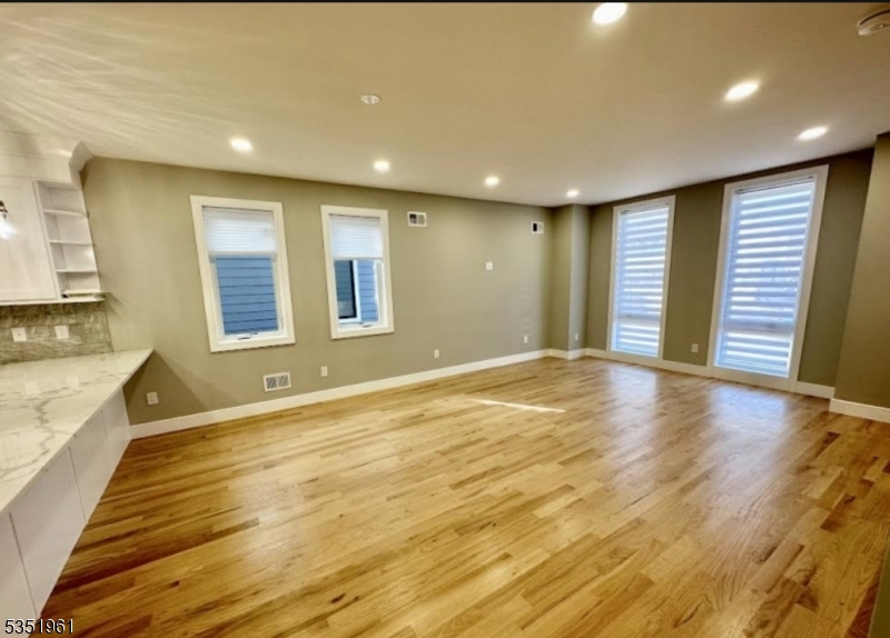 10 Washington Street, Unit B Montclair, NJ 07042 - Photo 1 of 24 a view of an empty room with wooden floor and a kitchen