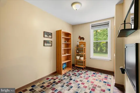 a bedroom with a dresser and a window