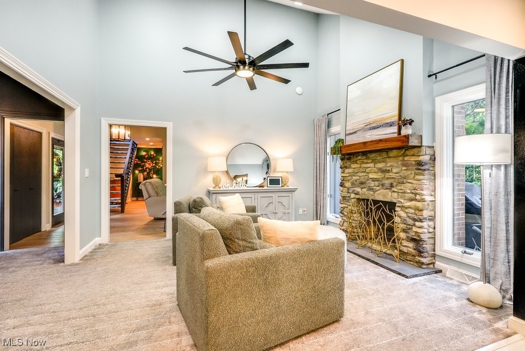 1598 Graham Road Silver Lake, OH 44224 - Photo 20 of 46 Living room featuring light colored carpet, ceiling fan, a towering ceiling, and a fireplace